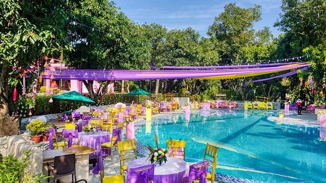 alt-text Poolside wedding venue with colorful decorations and lush greenery.