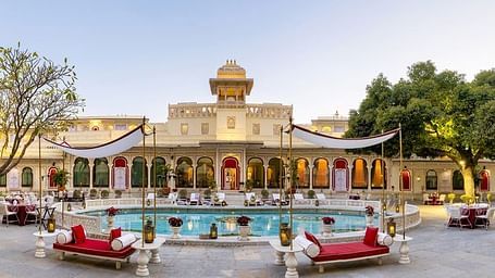 A facade image of Shiv Niwas Palace with a pool in front