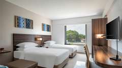 Standard twin room decked with two beds, television and a working desk at The Residency Towers Rameswaram