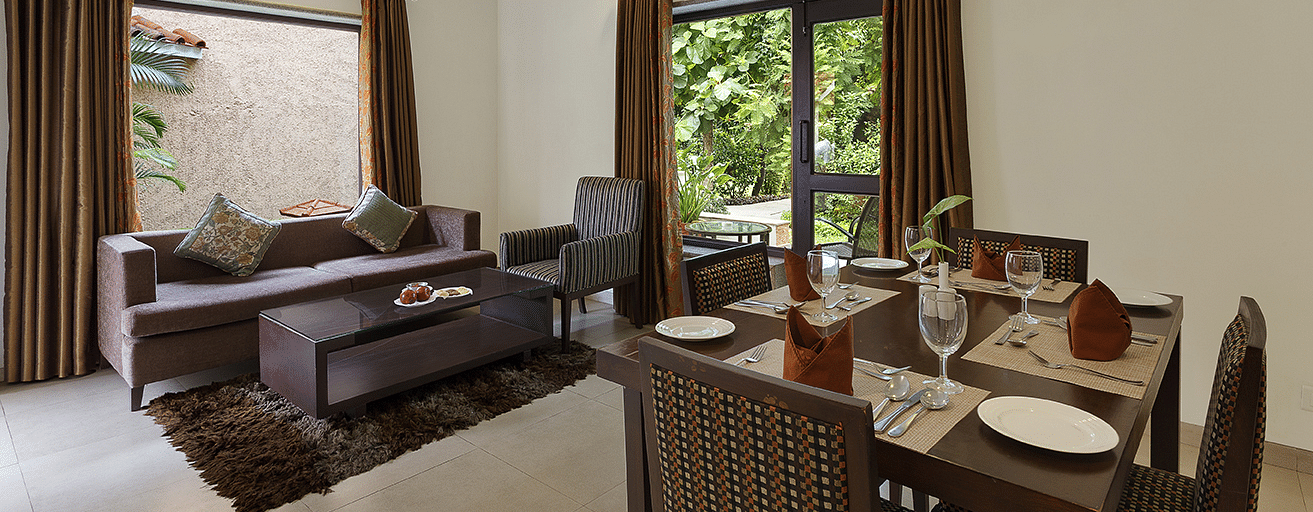 An image of a living area with sofa set and dining area on the other side. There is also a flat TV screen on the wall - The Riverview Retreat, Corbett
