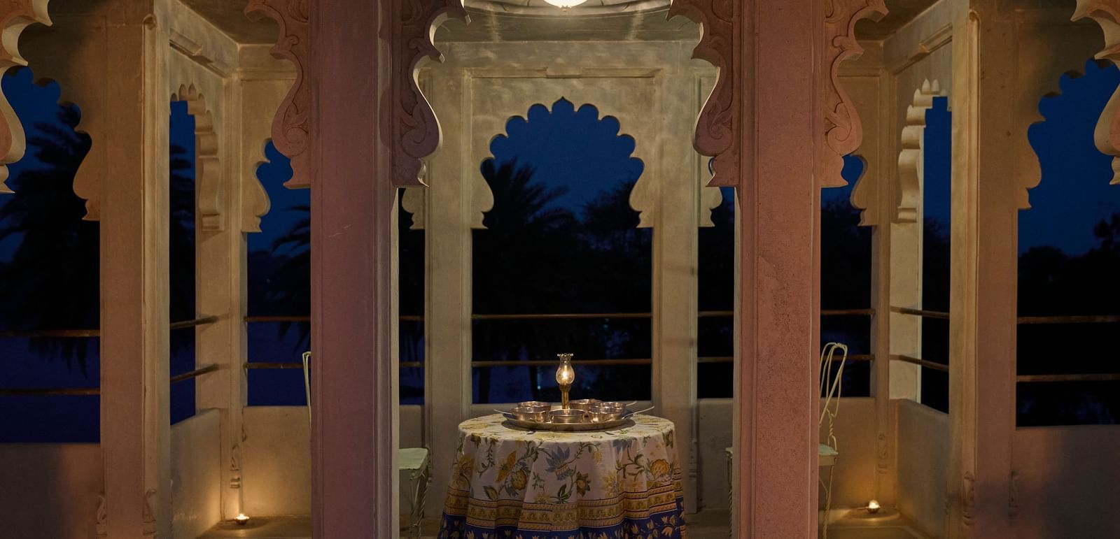 image of a balcony with arched pillars featuring a round table in the middle at Dev Shree, Deogarh