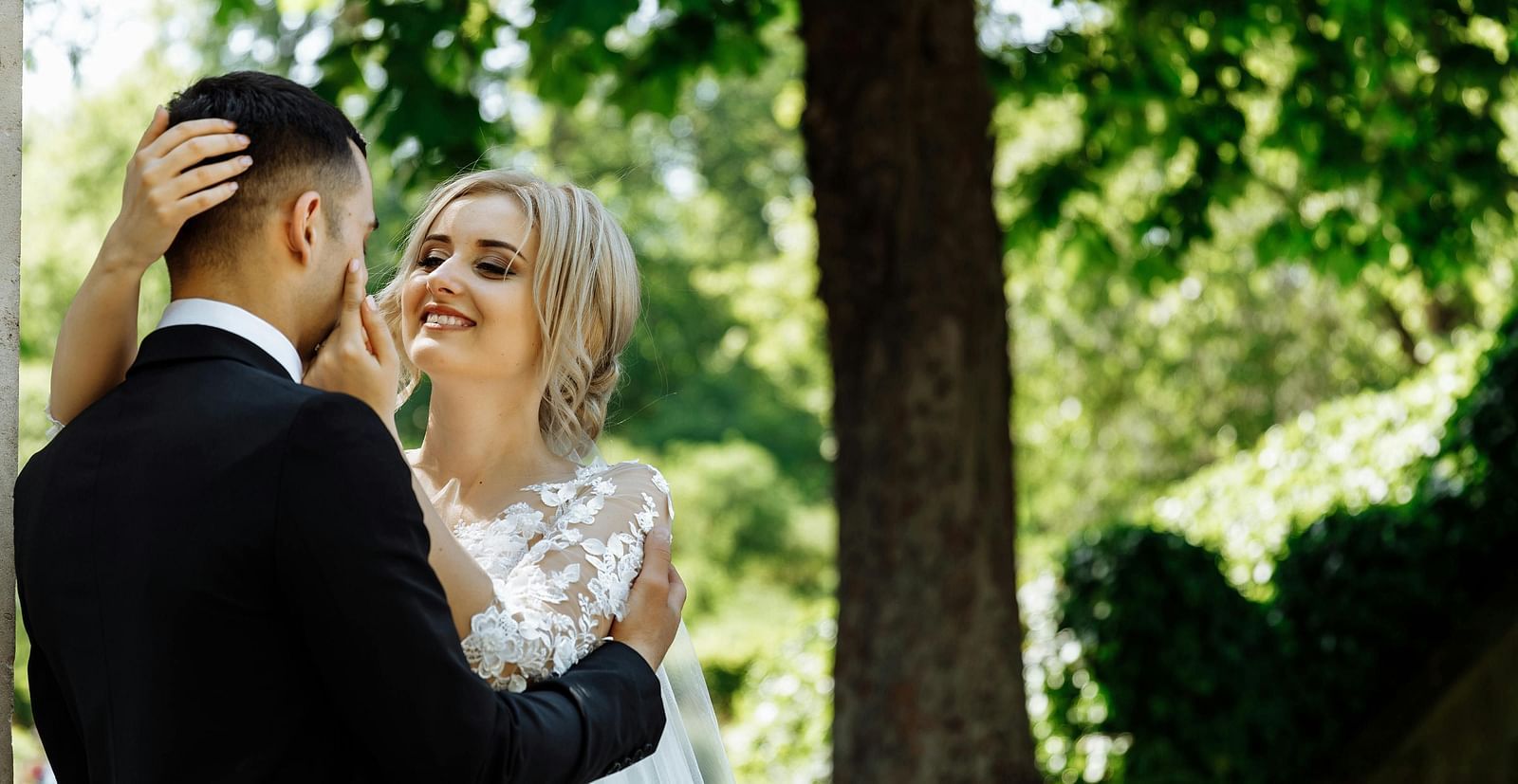A couple posing for a wedding photoshoot with a forest in the backdrop