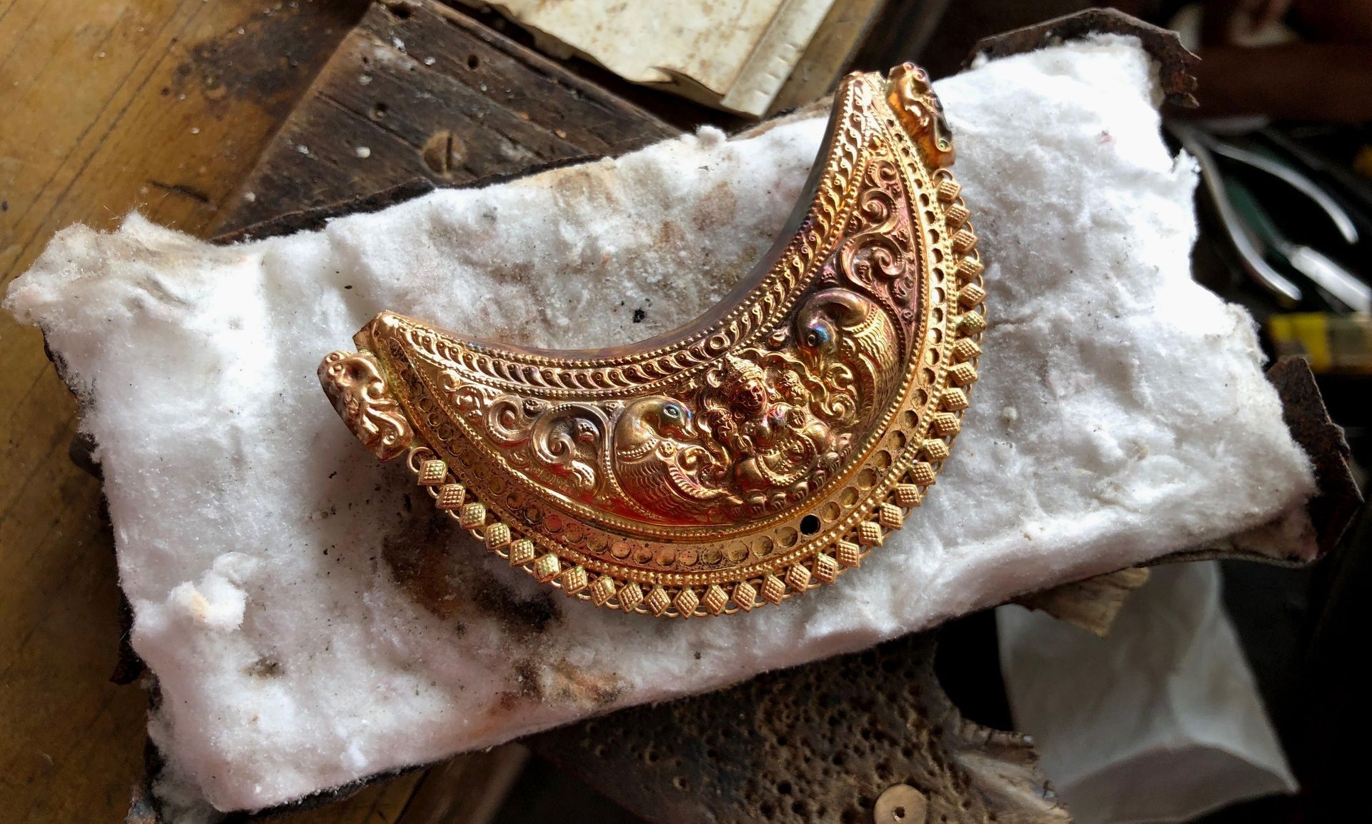 Intricately crafted gold kokkethathi in a workshop.