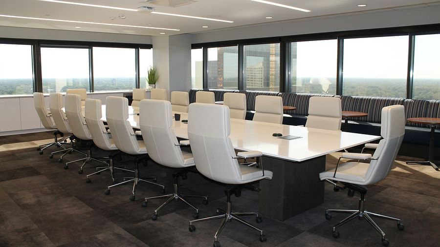 Spacious meeting room featuring a large conference table with neatly arranged chairs