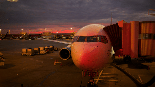 A close-up shot of an aircraft during a late evening with the aerobridge attached.