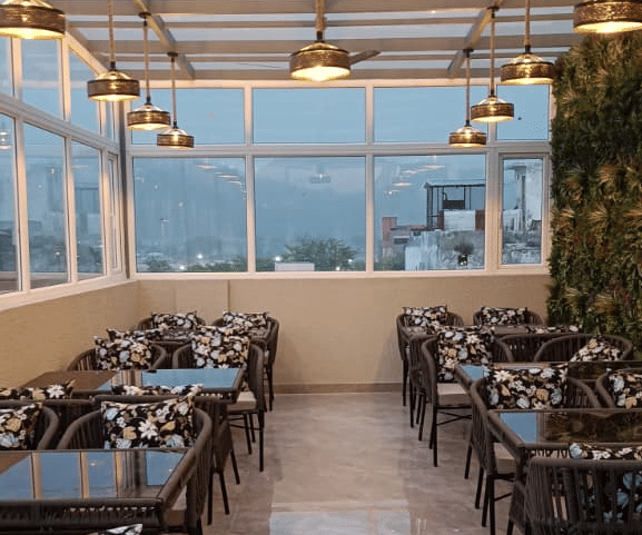 The rooftop caf&eacute; at dusk, lit by pendant lights, at Signum Tathastu Boutique Hotel, Haridwar