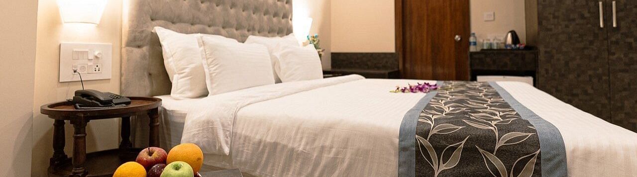 Elegant room with a bed, fruit bowl on the bedside table, and tufted headboard at The Verda de Miranda Resort.