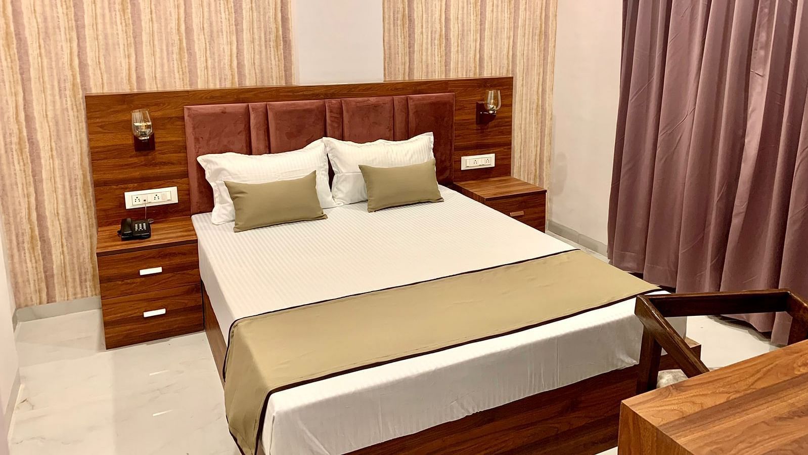 Comfy delux room with a plushy bed and a study table at at Hotel Mumbai House, Indore