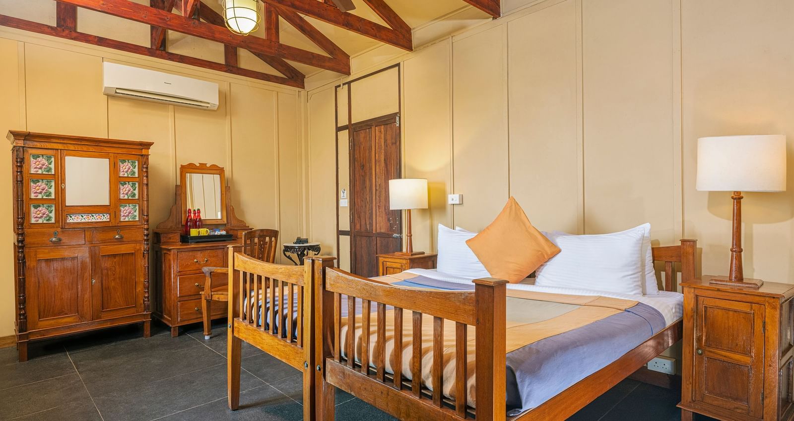 A double bed with side tables and lamps inside a Superior room | Mango Hill, Pondicherry