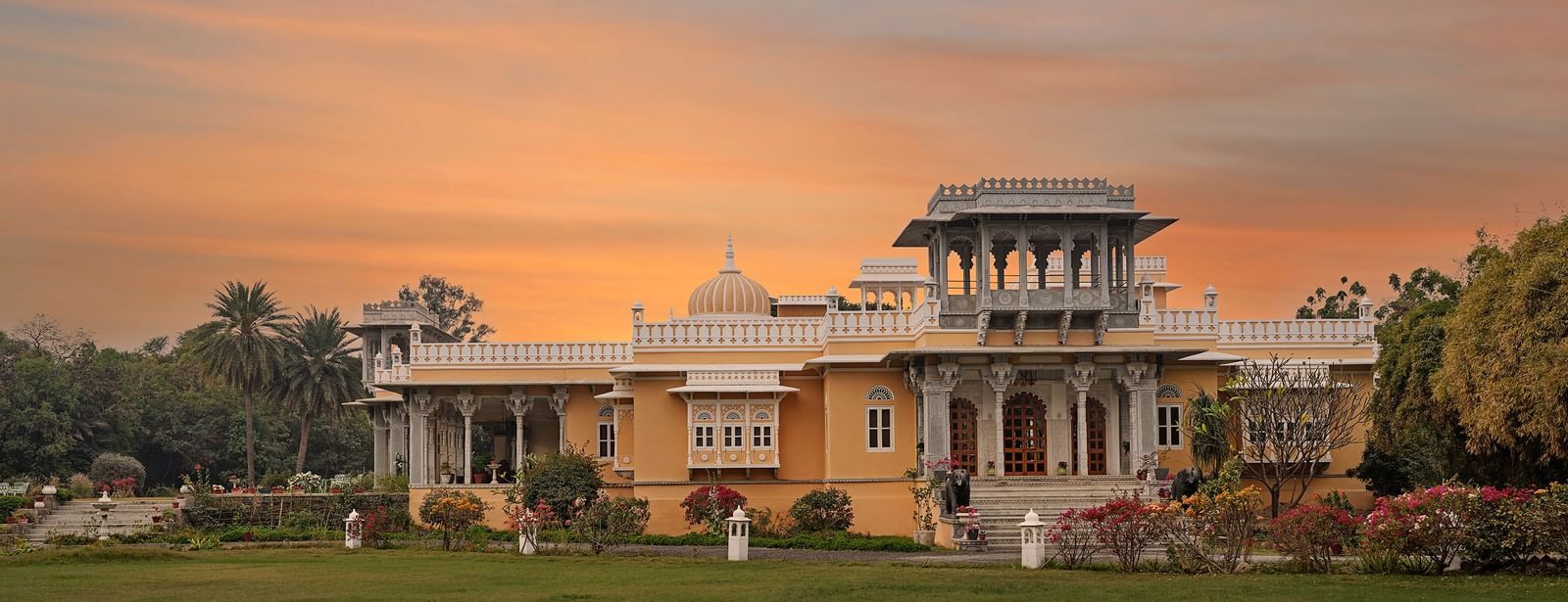 facade image of dev shree, deogarh with a sunset in the background
