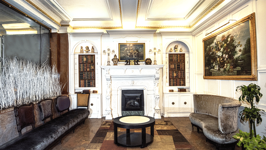 Lobby at Night Hotel Broadway featuring fireplace lounge seating patterned flooring decorative lighting and classic architectural details.