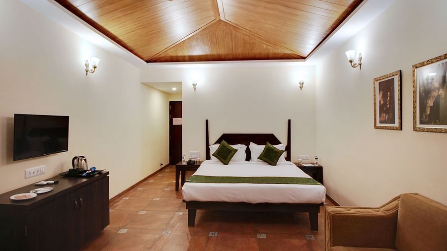 A double bed with sofa in Majesty room 1 at Rahi Forest View