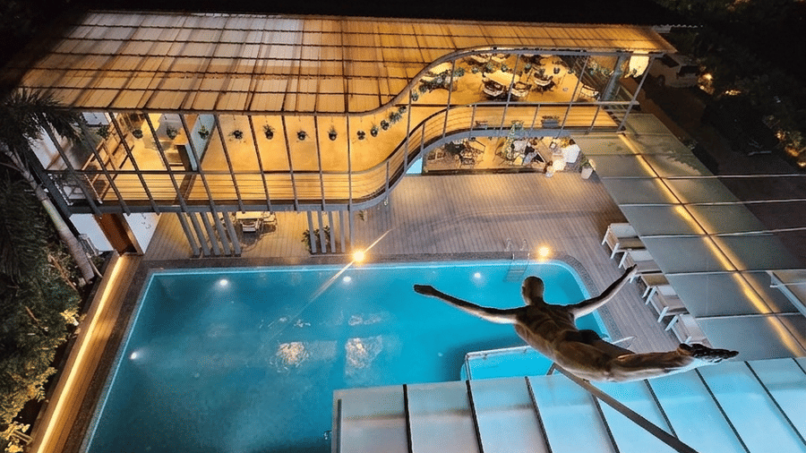 High-angle night view of an illuminated swimming pool and outdoor seating at BluSalzz Collection - Casa Onze, Arpora.
