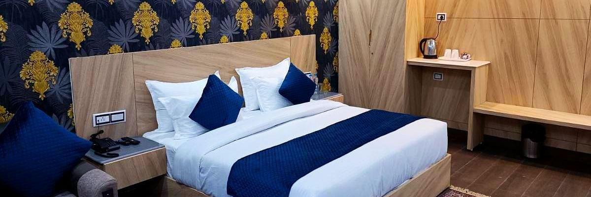 A Deluxe Room at DLS Nature Trinket Resort with a king size bed and a side table.
