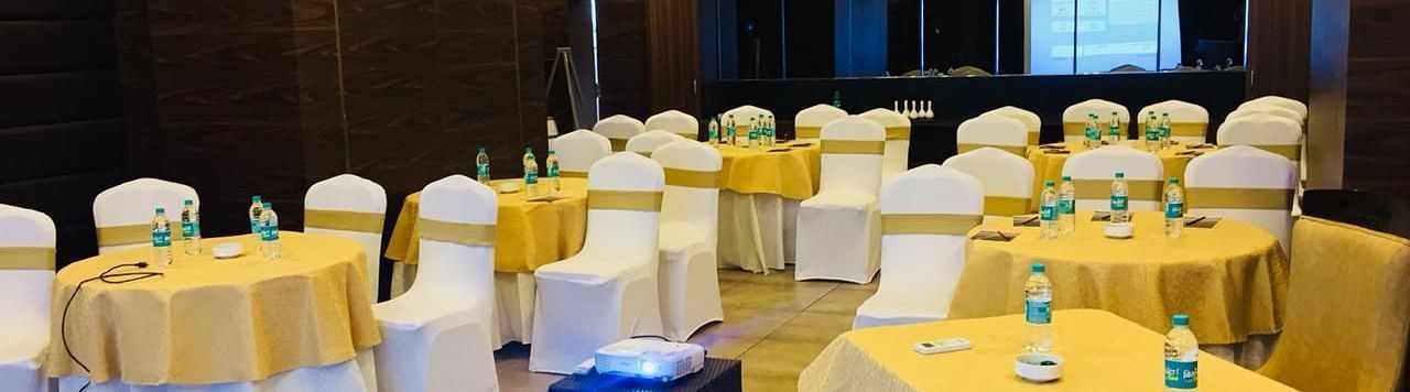 Image of a hall with round tables and chairs around it at Calux Grand Baga.