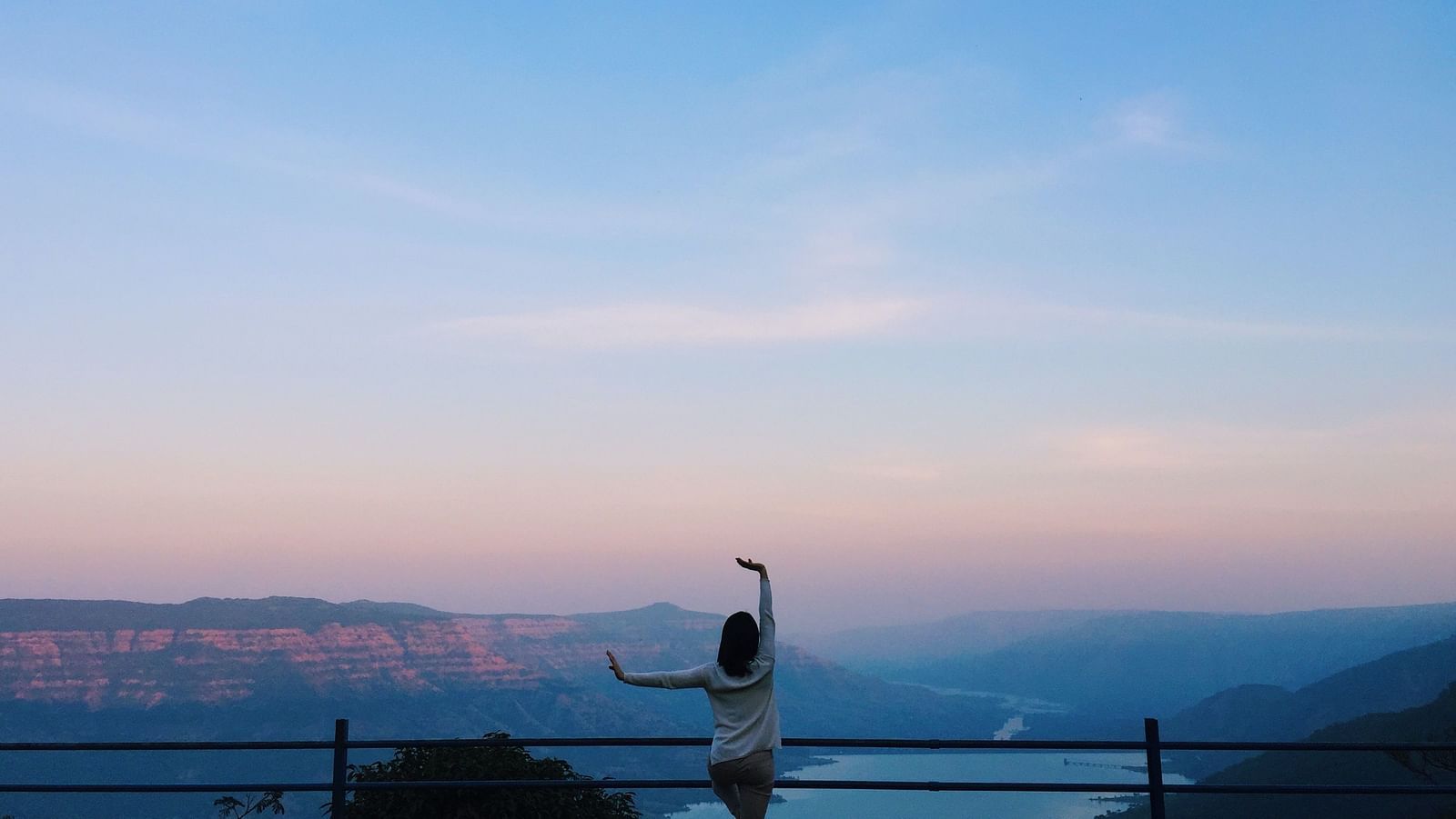 A person overlooking a valley at sunset with evening sky in the background