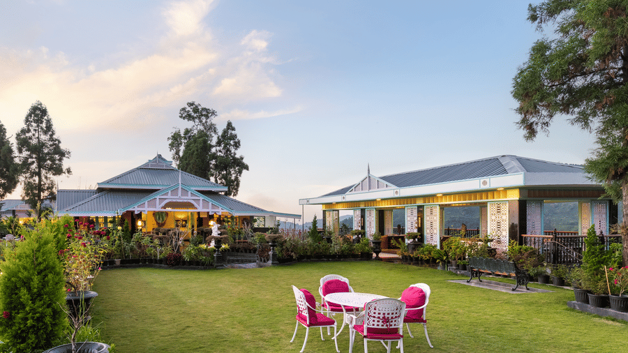 Lush green garden lawn with outdoor seating at sunset, Mayfair Manor, Jungpana.