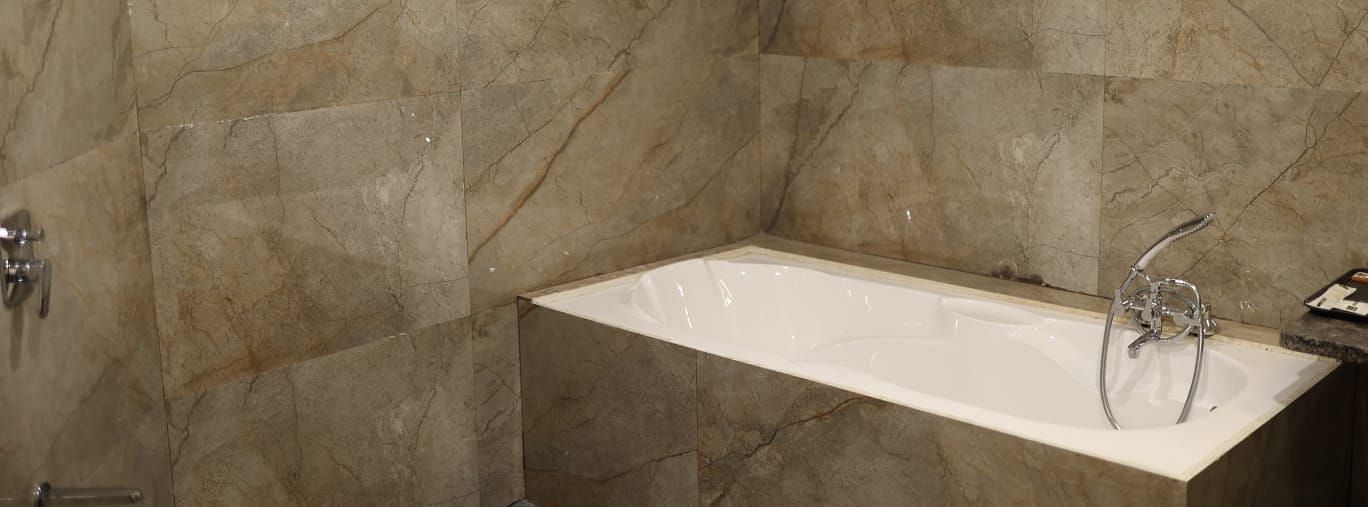 A close-up shot of a modern bathtub with a white interior and a light-coloured marble surround - Bamboo Saa Mulberry Resort, Pushkar