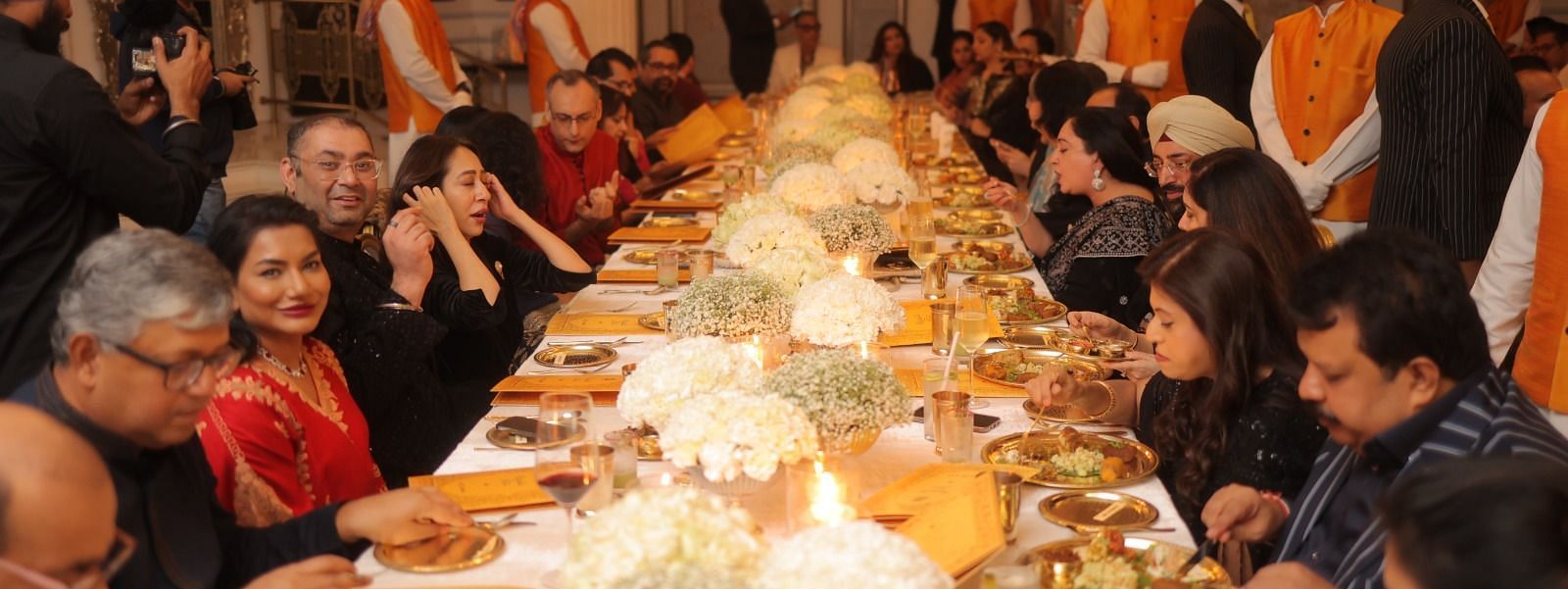Guests enjoying their meal at the Royal Gala Dinner, seated at a large table beautifully decorated with flower bouquets and served food