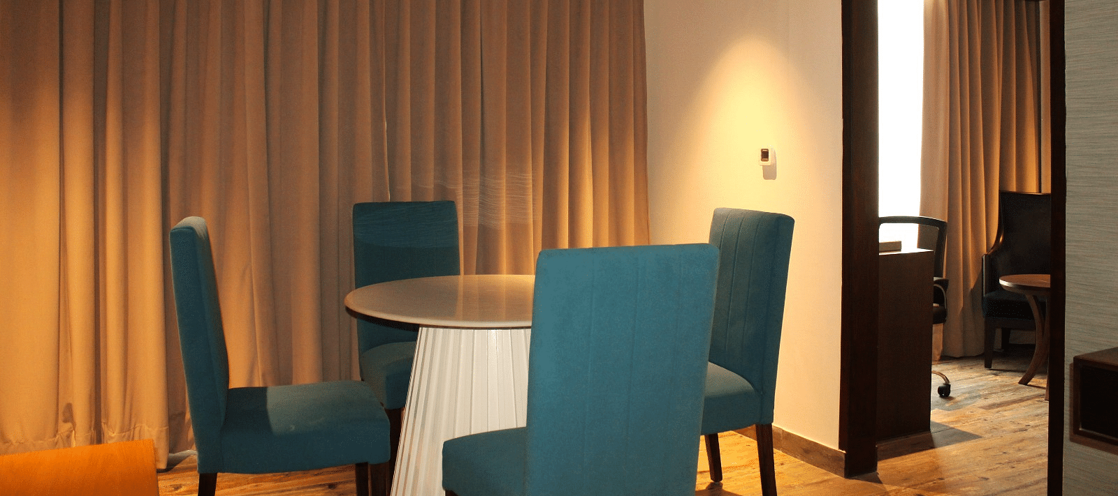 Close-up view of the dining space in the suite featuring a table and chairs at BluSalzz Residence, Amritsar.