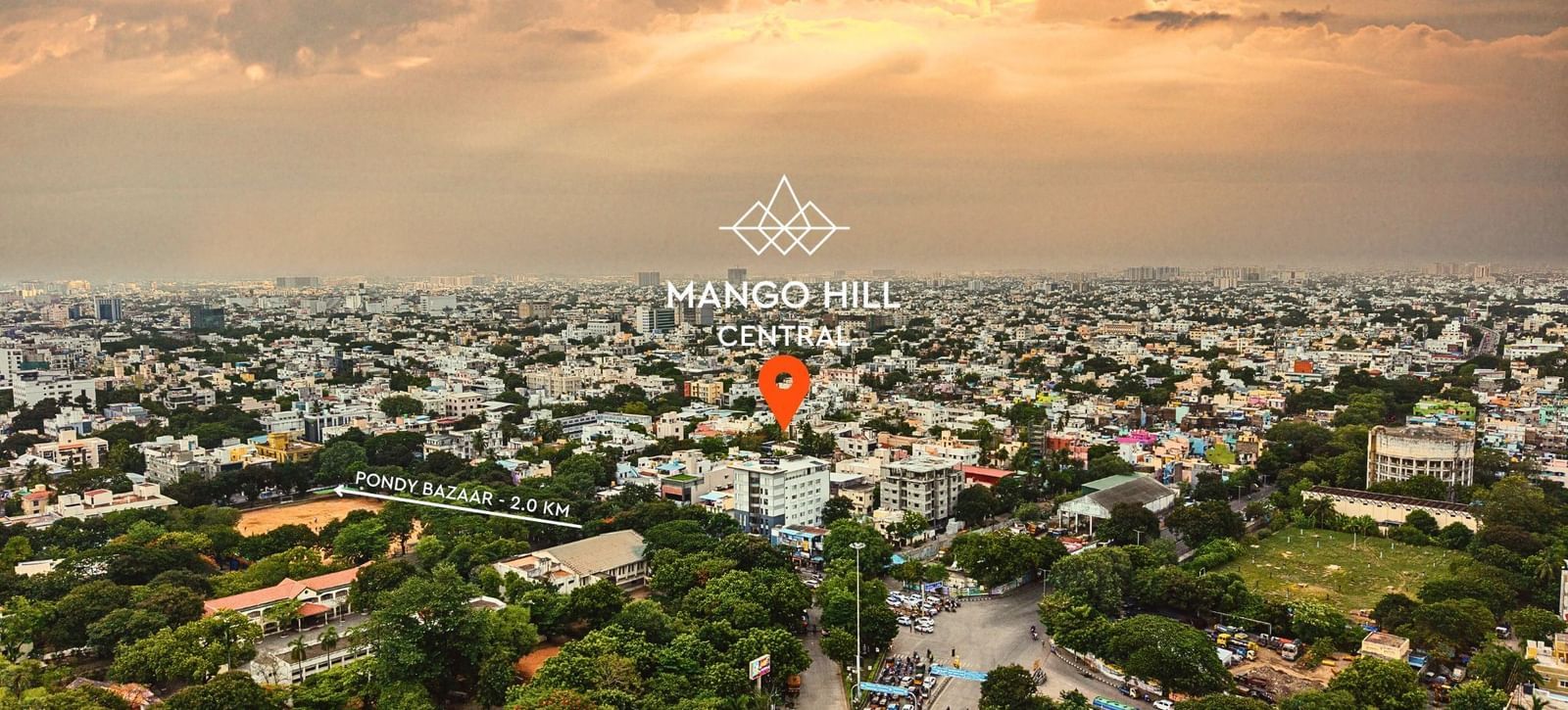 An aerial view of the city of Chennai at sunset. A red marker is visible on one of the buildings.