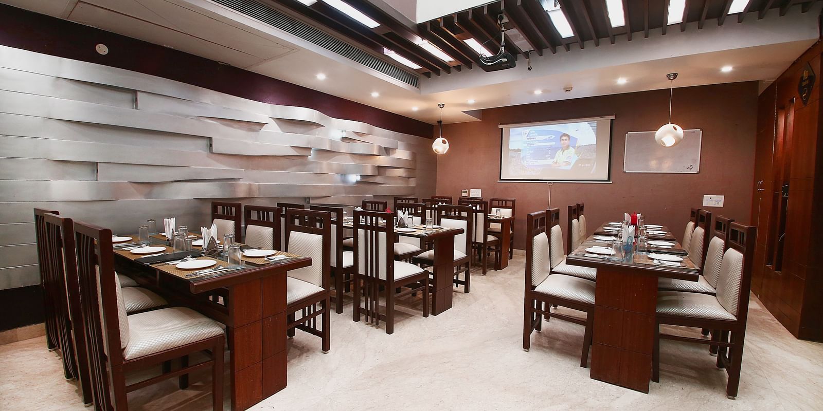 Spacious restaurant with multiple dining tables at Hotel Emerald, Chandigarh