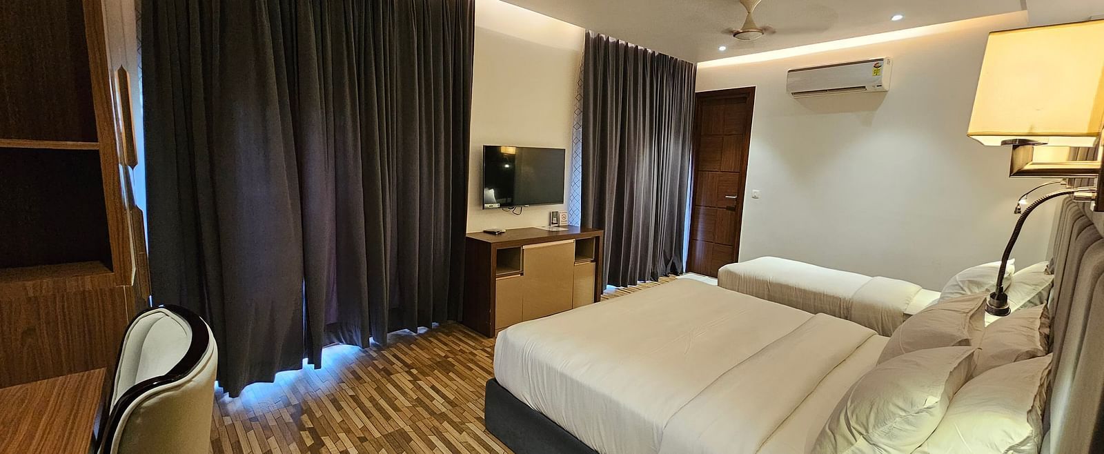 A family executive room at Eminence The Corbett with curtains drawn over the windows