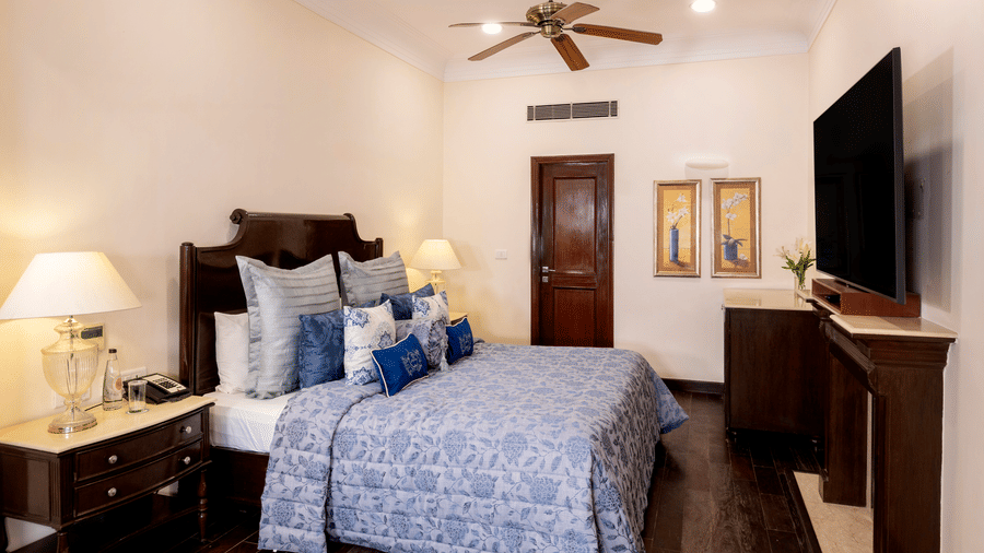 image of a king size bed at the Claridges Room with a wall mounted television at The Claridges Nabha Residence