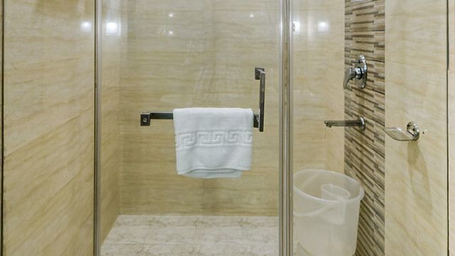 Modern resort bathroom with a glass-enclosed shower and clean design.