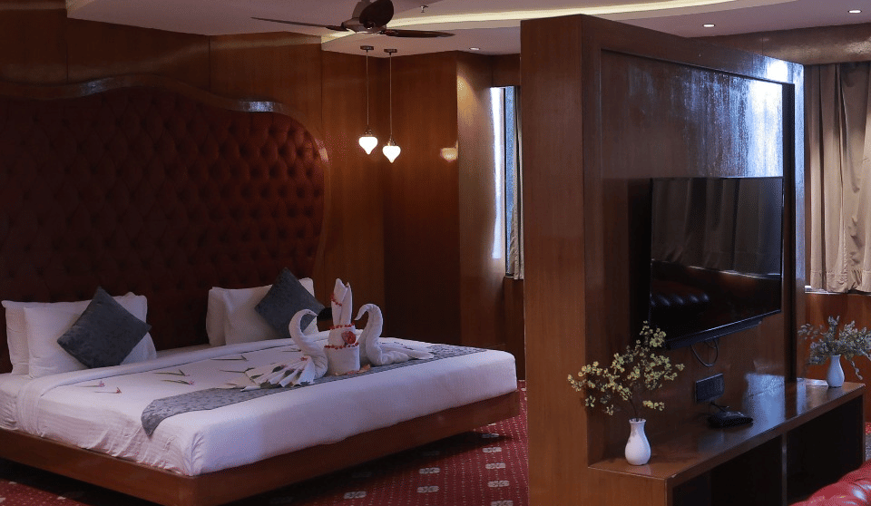 Sky Suite bedroom with a king bed and lounge seating under cove lighting