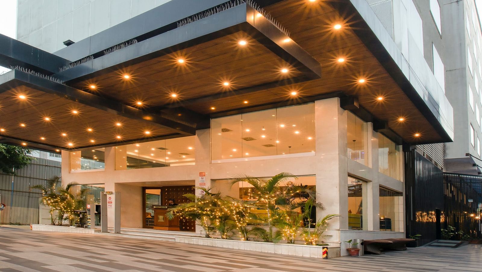 Facade of The Cunningham Hotel under a clear sky as the ceiling of the entrance is lit up in warm lights