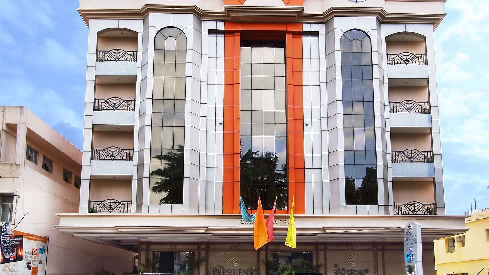 Facade of The President Hotel Jayanagar, Bangalore with striking red accents and a majestic entrance, showcasing a blend of traditional and contemporary architecture 