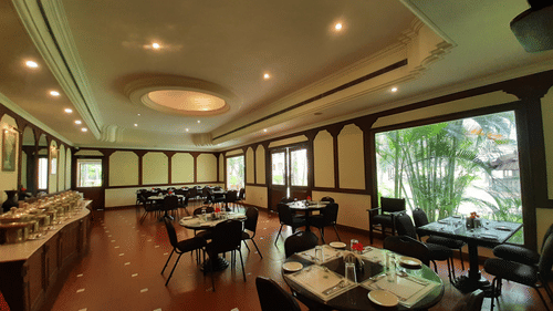 A spacious dining hall with neatly arranged tables, bright interiors, and large windows, offering a welcoming ambience at one of the best places to eat in Coimbatore | Black Thunder