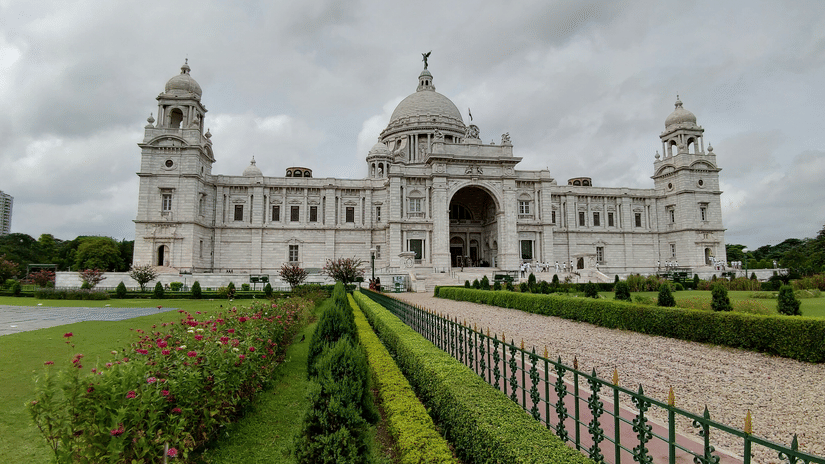Grand marble monument with domes, landscaped lawns, and pathways at Victoria Memorial, Kolkata.