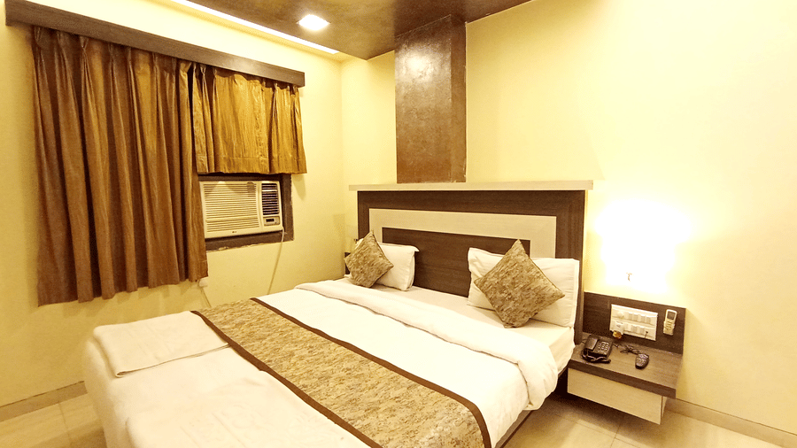 Cozy bedroom interior featuring a neatly made bed with a patterned runner and warm bedside lighting.