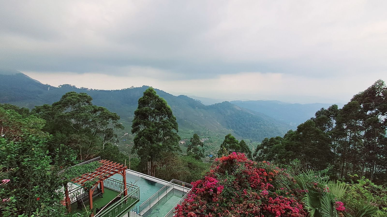  Aerial view of the hotel nestled among trees, with a breathtaking mountain vista in the background