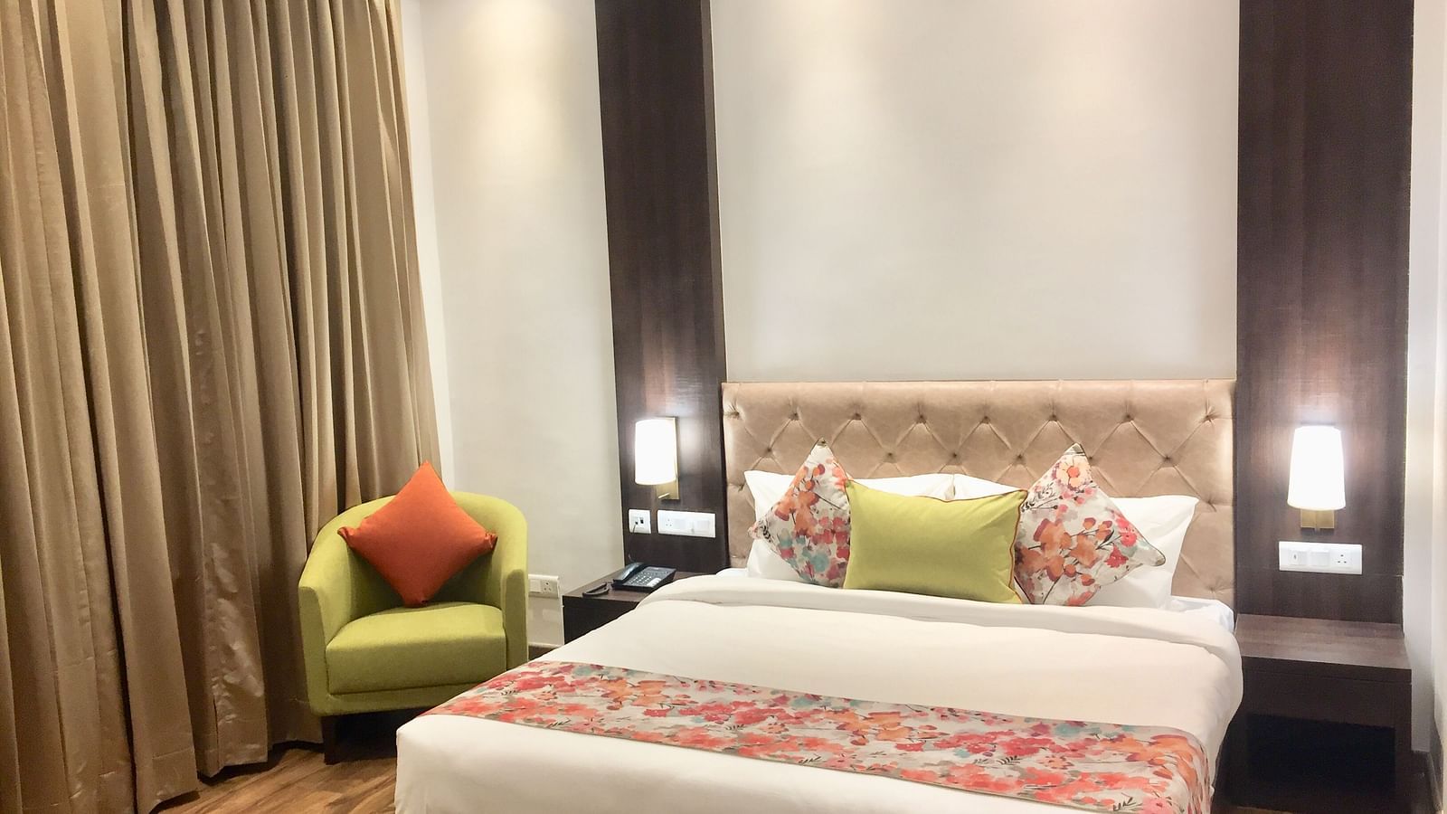 Deluxe Rooms at Hotel Le ROI Lake View Koti captured with curtained windows and green furniture inside the room1