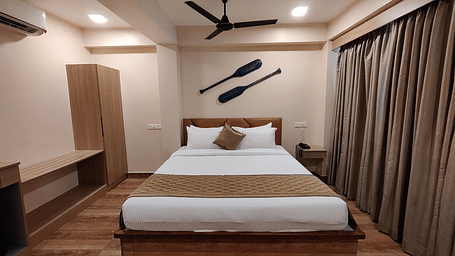 Comfortable bedroom with a king-sized bed, wooden flooring, and ceiling fan