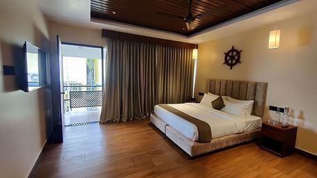 Side view of the room showcasing the veranda with sliding glass doors and greenery