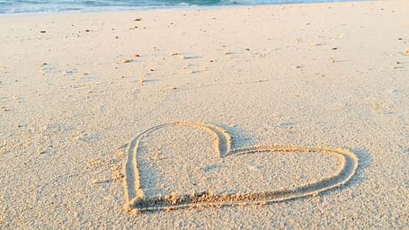 A shape of a heart on the sand at the beach