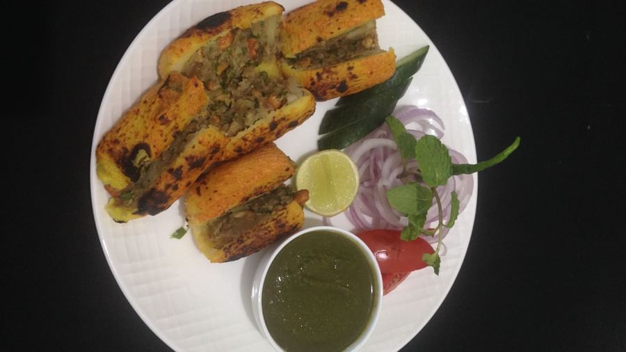 A plate of seekh kebabs garnished with green chilies, onions, and mint chutney | Daksh The Madhuvan Suites