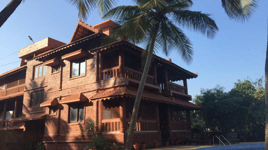 Exterior view of multi-storey Paradise Lagoon Resort featuring wooden balcony, sloped red-tiled roof, and palm trees.