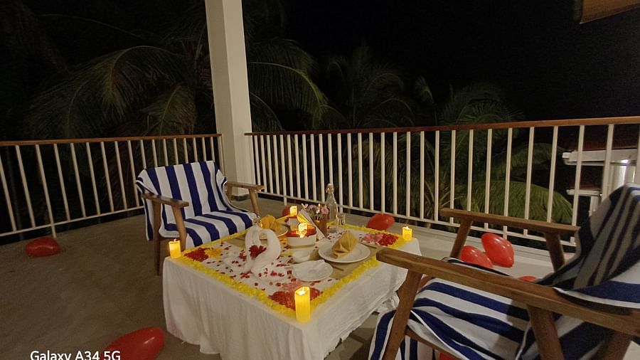 Romantic dinner setup on the balcony with a table for two, overlooking the serene outdoor area under soft lighting - Sea Hills Resort, Swaraj Dweep (Havelock)
