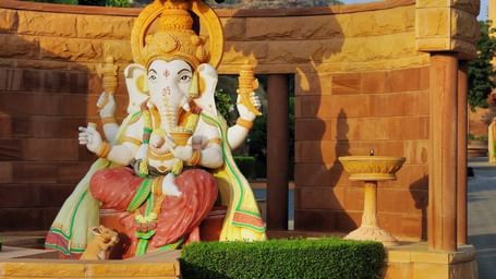 A ganesh idol placed out in the open with the sun shining down on it - Khajrana ganesh mandir