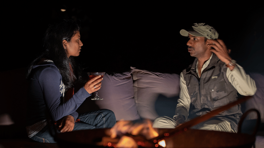 Guests gathered around a bonfire for a night stargazing experience at Evolve Back Kabini