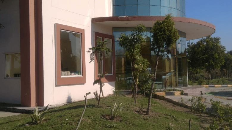 Side view of a modern glass-fronted building with lawn at Livbox, Rudrapur.