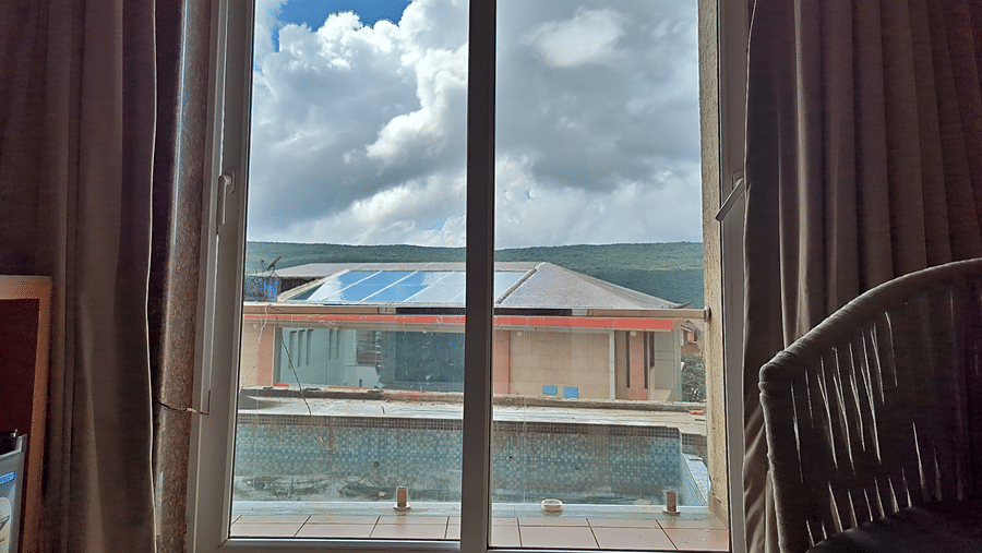 Window overlooking surrounding buildings and a scenic outdoor view.