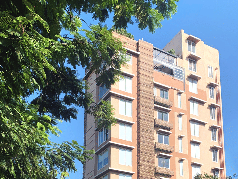 Facade of Theory9 Service Apartments in Bandra during the day with trees in view.
