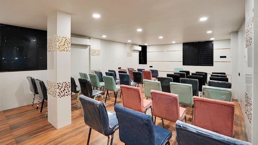 A conference hall with chairs facing the screen at Hotel Regal Heaven, Pune.