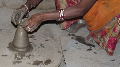 image of a woman with her head covered doing pottery